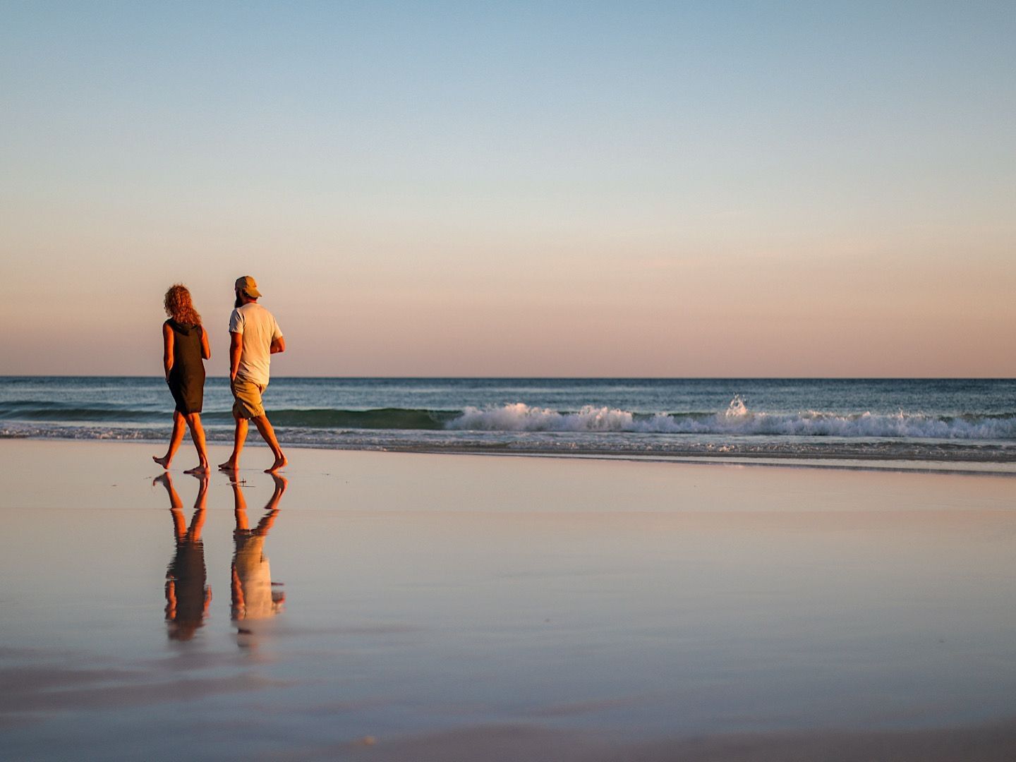 A couple walking by the beach in twilight near Falmouth Tides