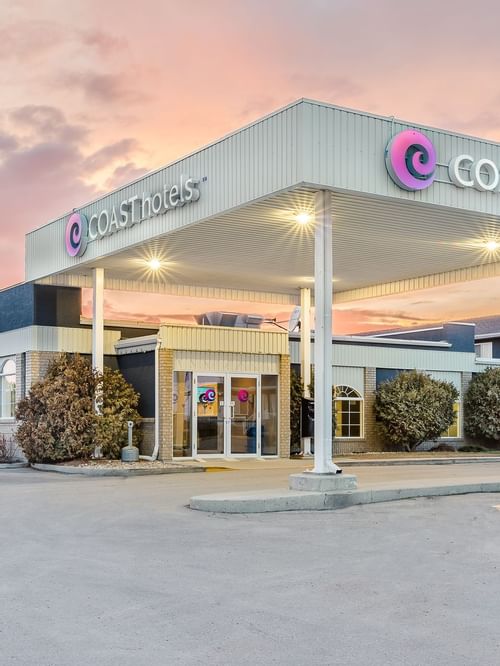 Exterior of Coast Swift Current Hotel with pink sky