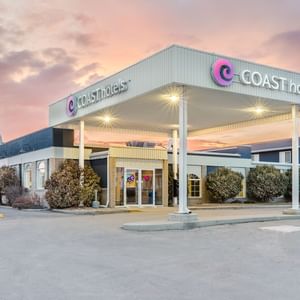 Exterior of Coast Swift Current Hotel with pink sky