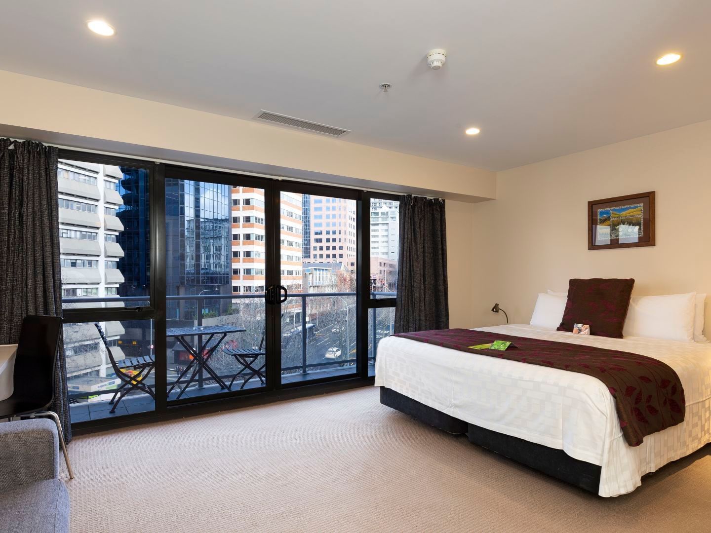 King bed & balcony lounge in City View Studio Apartment at Hotel Grand Chancellor