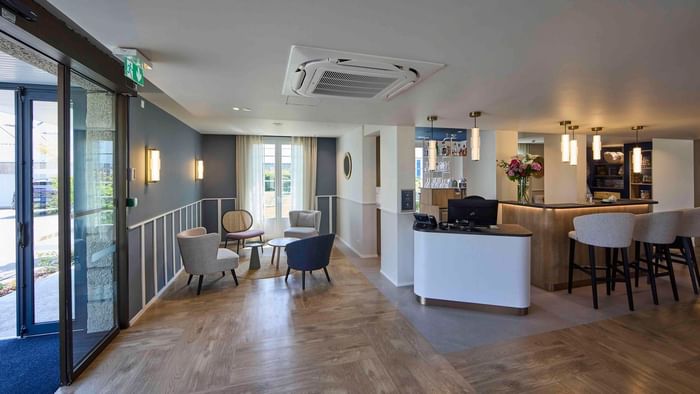 Salon d'accueil avec bar et fauteuils confortables à l'Hôtel La Marébaudière.