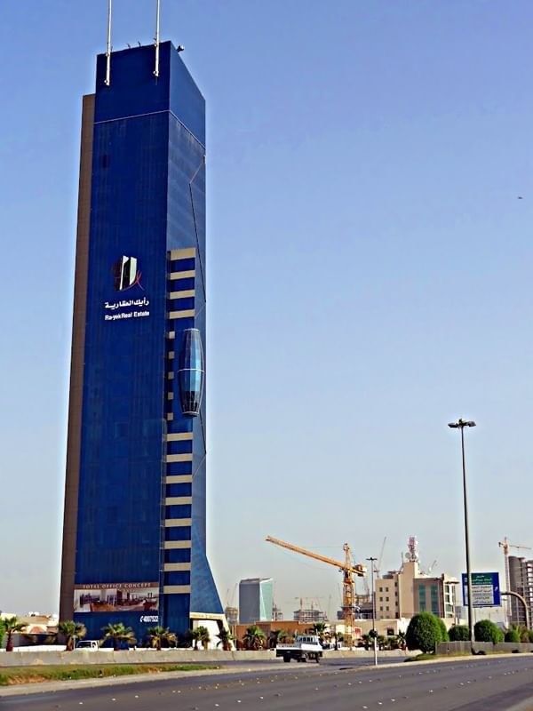 Tall blue glass Nakheel tower by a clear sky near Cantonal Hotel by Warwick Riyadh