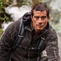 Bear Grylls in a jacket and backpack at Royal on the Park Hotel
