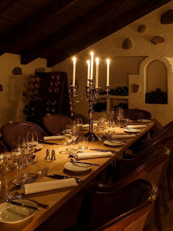 Candlelit dining table in a cozy wine cellar at Kokkedal Slot Copenhagen by Warwick in Hørsholm.