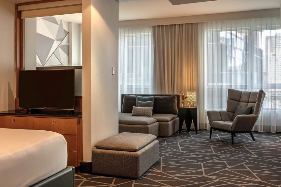 TV facing the bed with a separate living area in Premium Loft Suite at Warwick Le Crystal Montreal