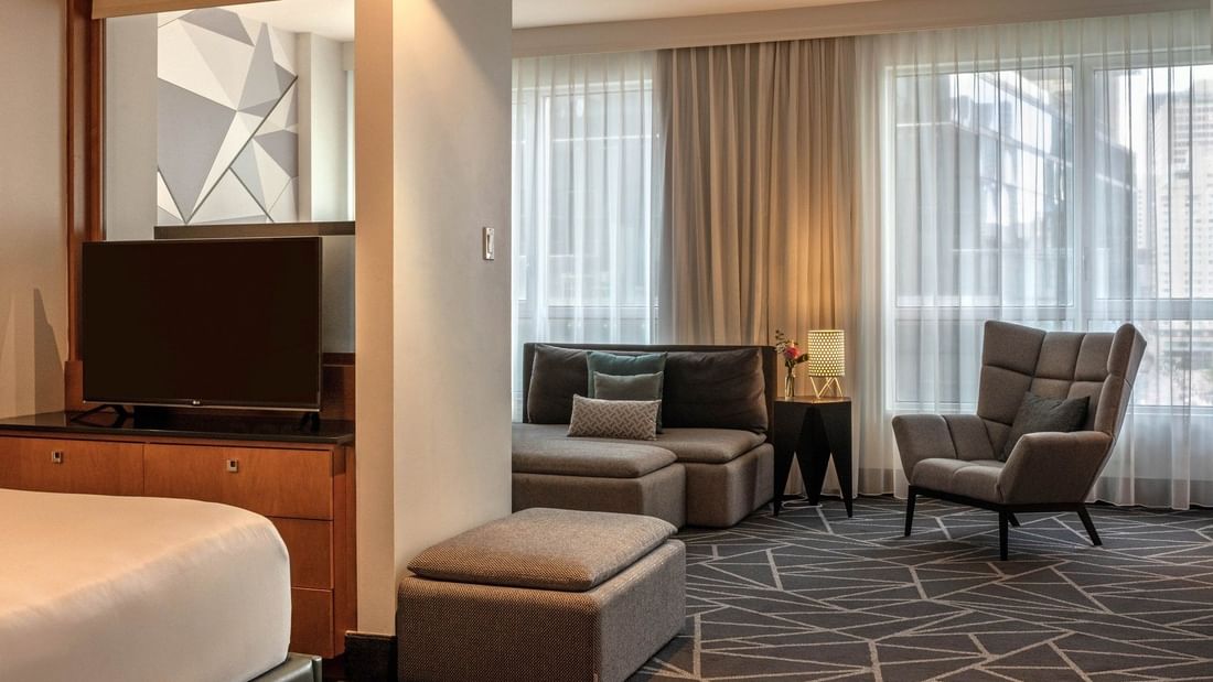 TV with bed and separate living area in Premium Loft Suite at Warwick Le Crystal Montreal