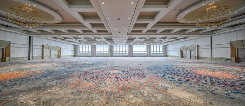 Spacious Grand Ballroom at The Diplomat Resort with patterned carpet, modern chandeliers, and large windows
