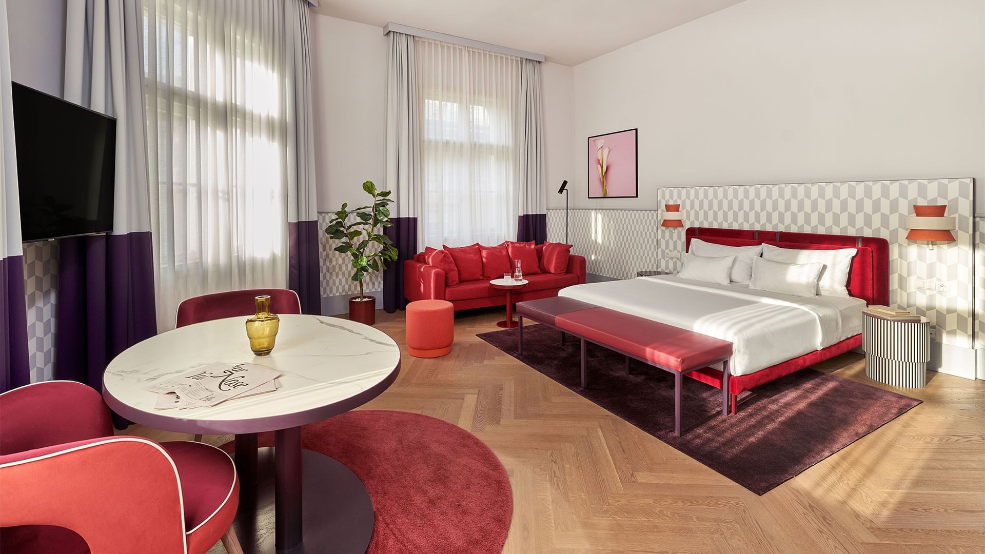 Stylová Junior Suite s postelí, pohovkou a stolem v Falkensteiner Hotel Prague v Praze.