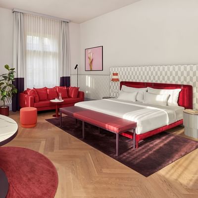 Stylová Junior Suite s postelí, pohovkou a stolem v Falkensteiner Hotel Prague v Praze.