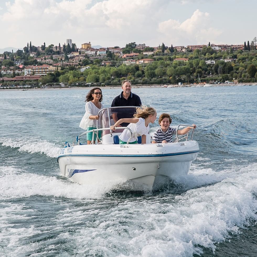 Famiglia felice in gita in barca sul lago in una giornata di sole.