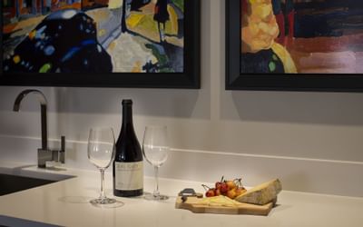 Champagne bottle with two glasses and a cheese plate on a countertop in a suite at The Paramount Hotel Seattle