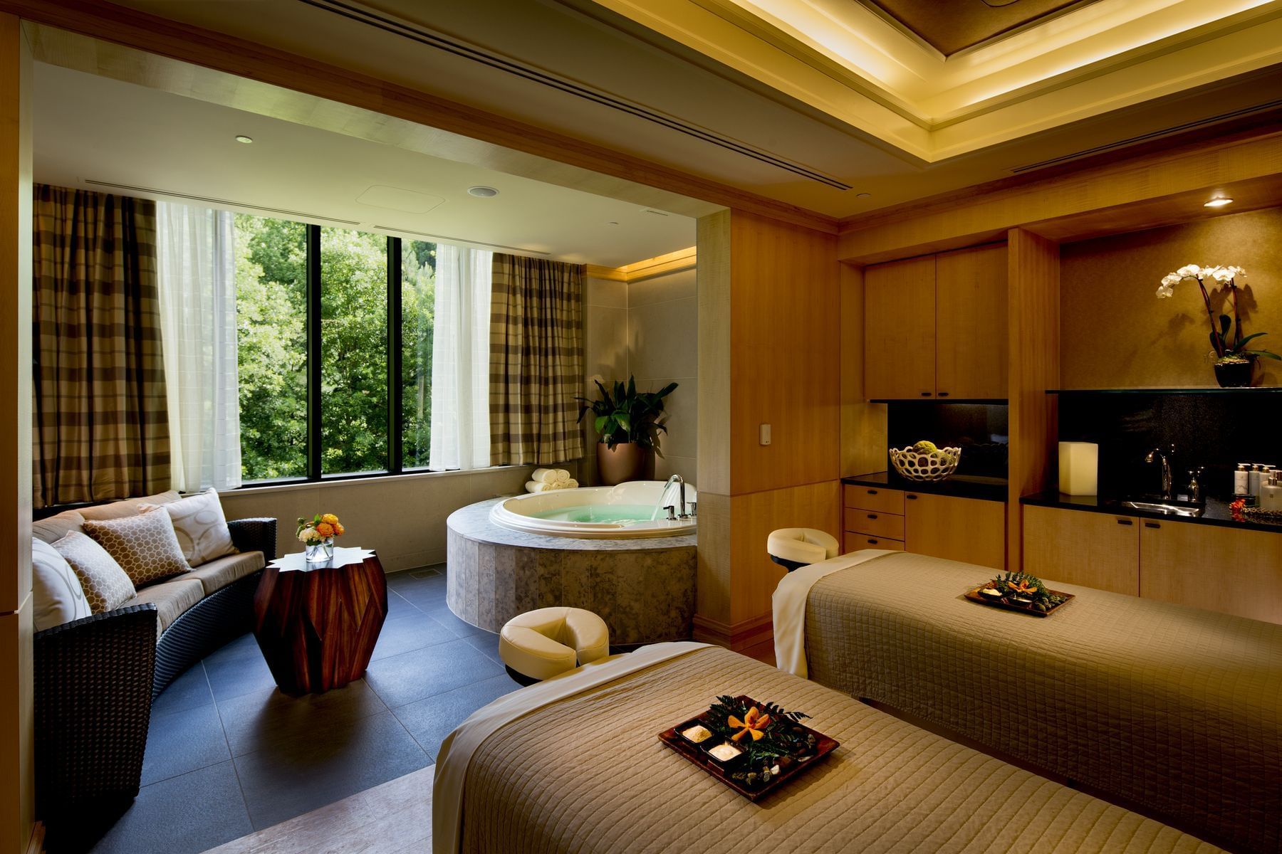 Relaxing massage beds, lounge area & jacuzzi in The Spa treatment room at The Umstead Hotel and Spa