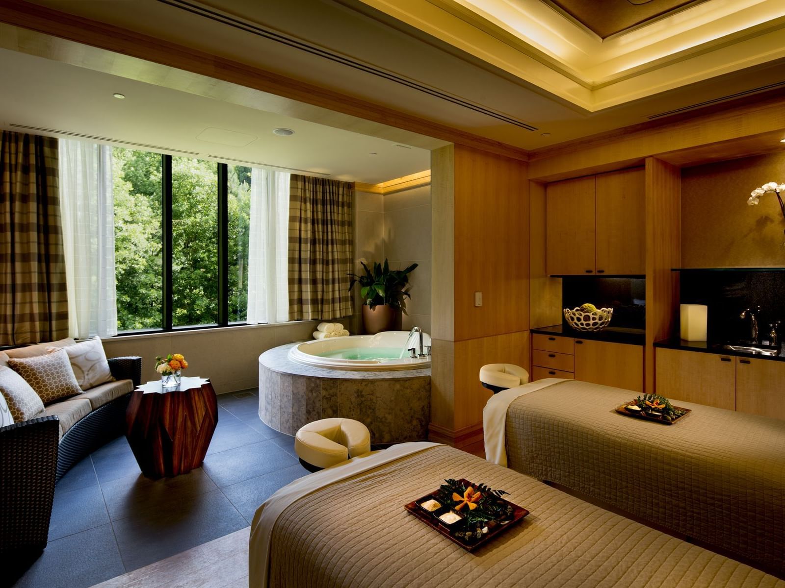 Relaxing massage beds, lounge area & jacuzzi in The Spa treatment room at The Umstead Hotel and Spa