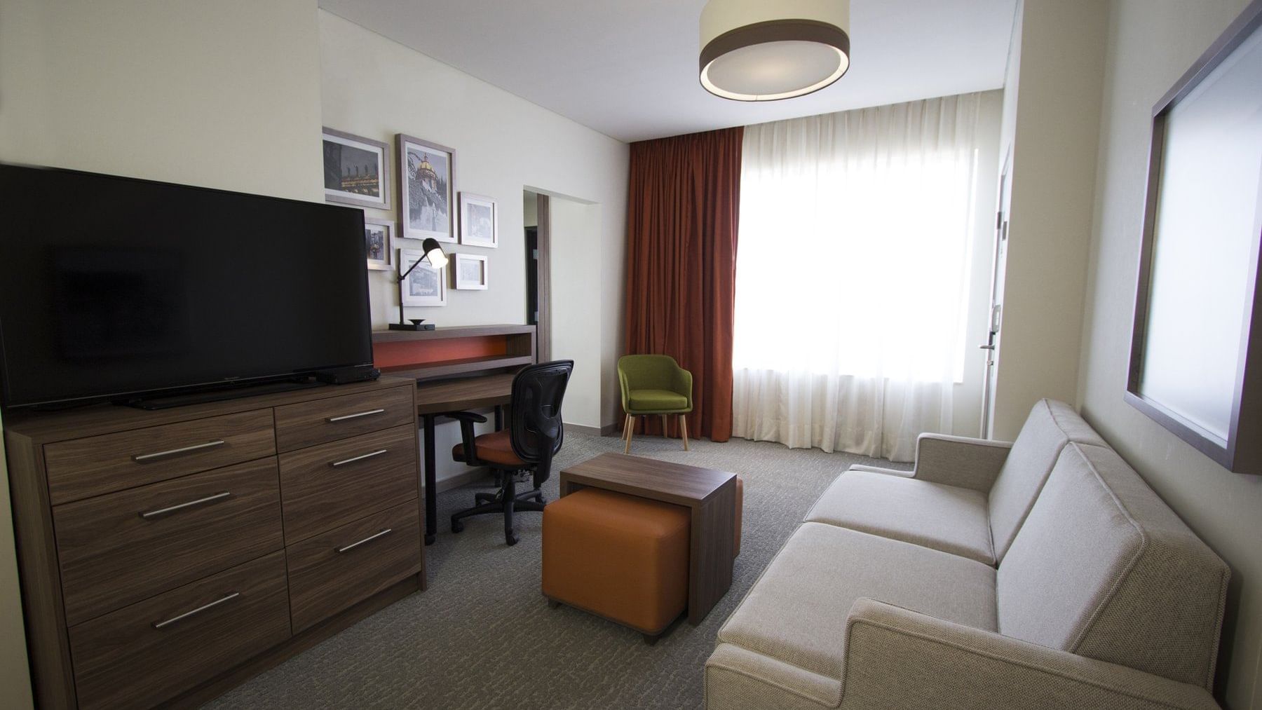 Comfortable couch with a TV in Suite King at Fiesta Inn Suites Aeropuerto del Bajío Silao