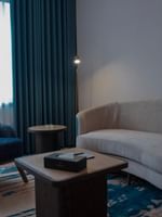 Living area with blue chairs and couch in Premium Club Room at Warwick Hotel & Spa - Jeddah.