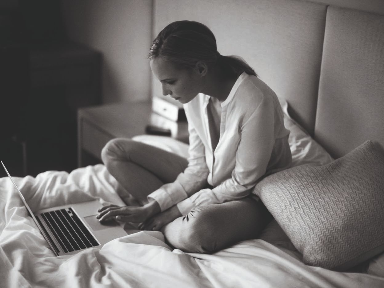Woman working on a laptop in a room at Crown Hotels
