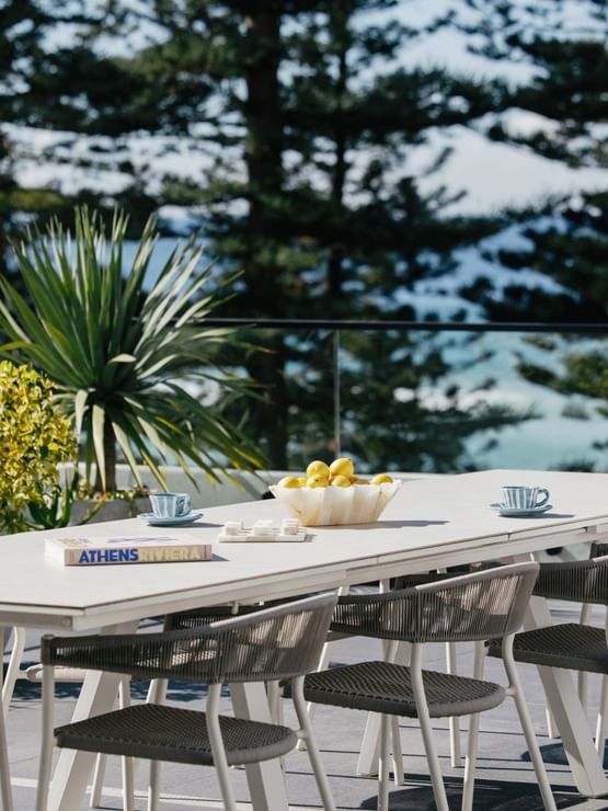Elysium Suite at Elysium Manly with an outdoor dining table, woven chairs near a lemon bowl, best places to stay in Manly