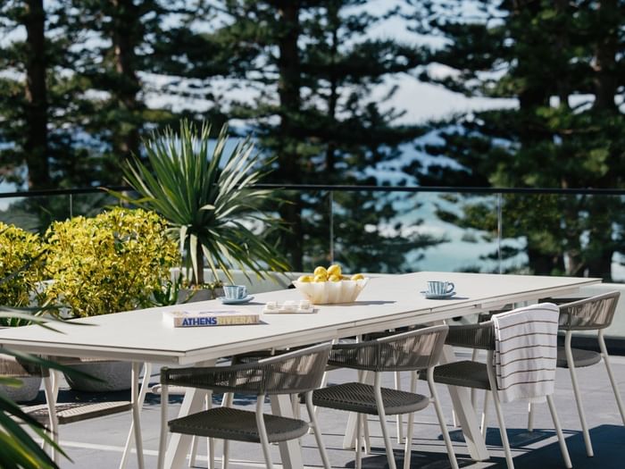 Elysium Suite at Elysium Manly with an outdoor dining table, woven chairs near a lemon bowl, best places to stay in Manly