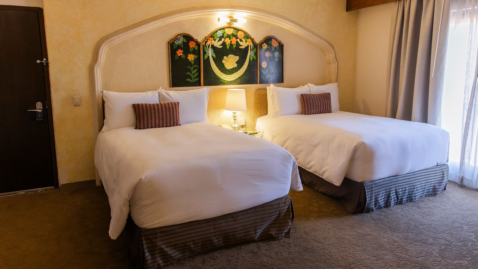 Master Suite con dos camas dobles, ropa blanca, arte decorativo y lámpara central en Quinta Real Zacatecas