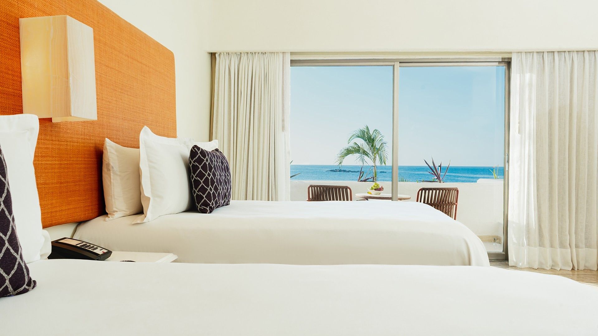 Nightstand by the cozy bed in Two Double Deluxe with private balcony seating & ocean views at Camino Real Zaashila Huatulco