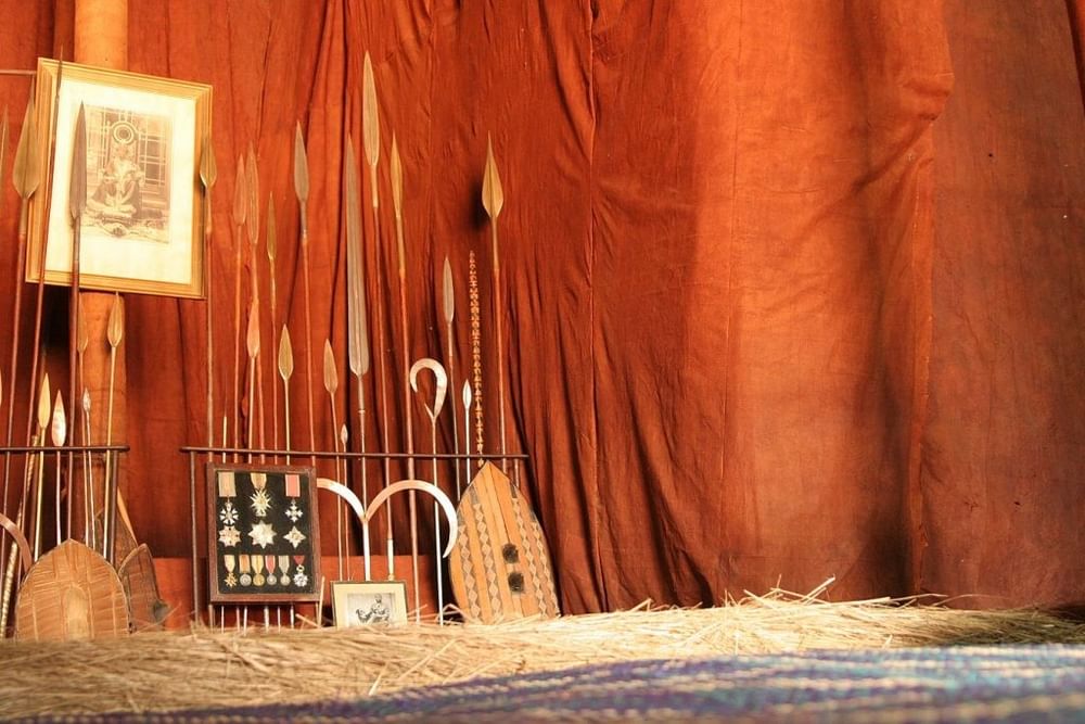 Traditional Ugandan artifacts and woven items displayed against rich orange fabric backdrop at Kampala Serena Hotel