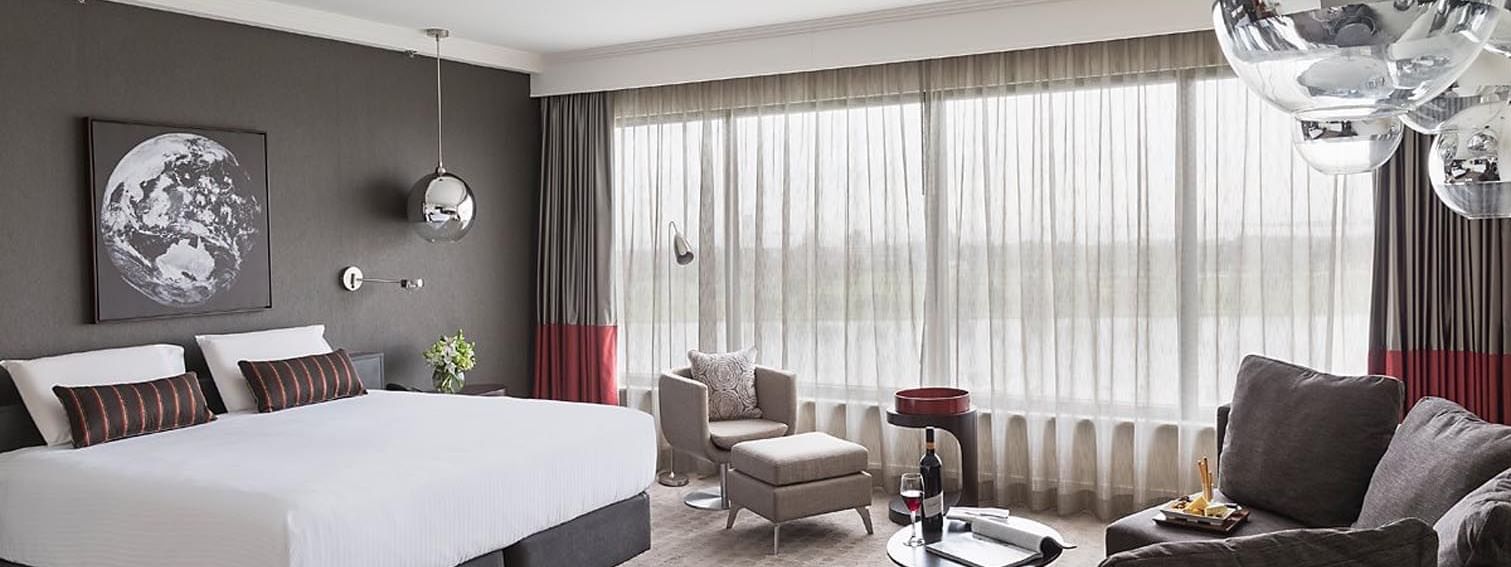 King bed and seating in Deluxe Room at Pullman Albert Park