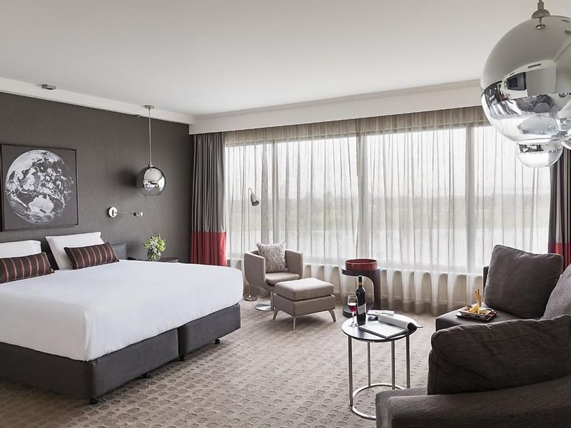 King bed and seating in Deluxe Room at Pullman Albert Park