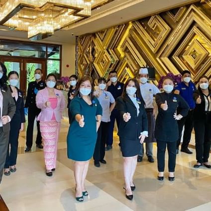 Hotel staff posing by an entrance at Chatrium Royal Lake Yangon