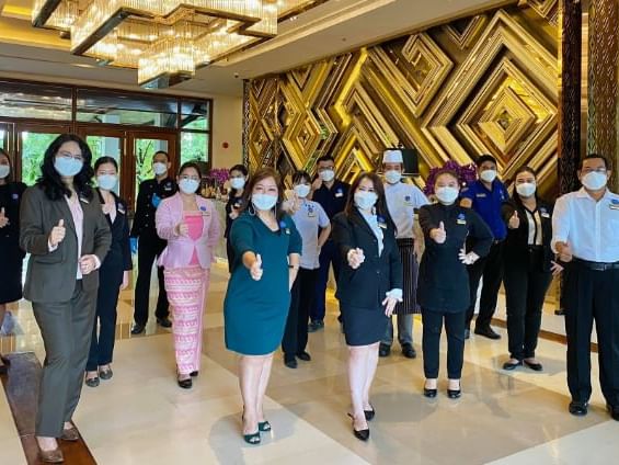 Hotel staff posing by an entrance at Chatrium Royal Lake Yangon