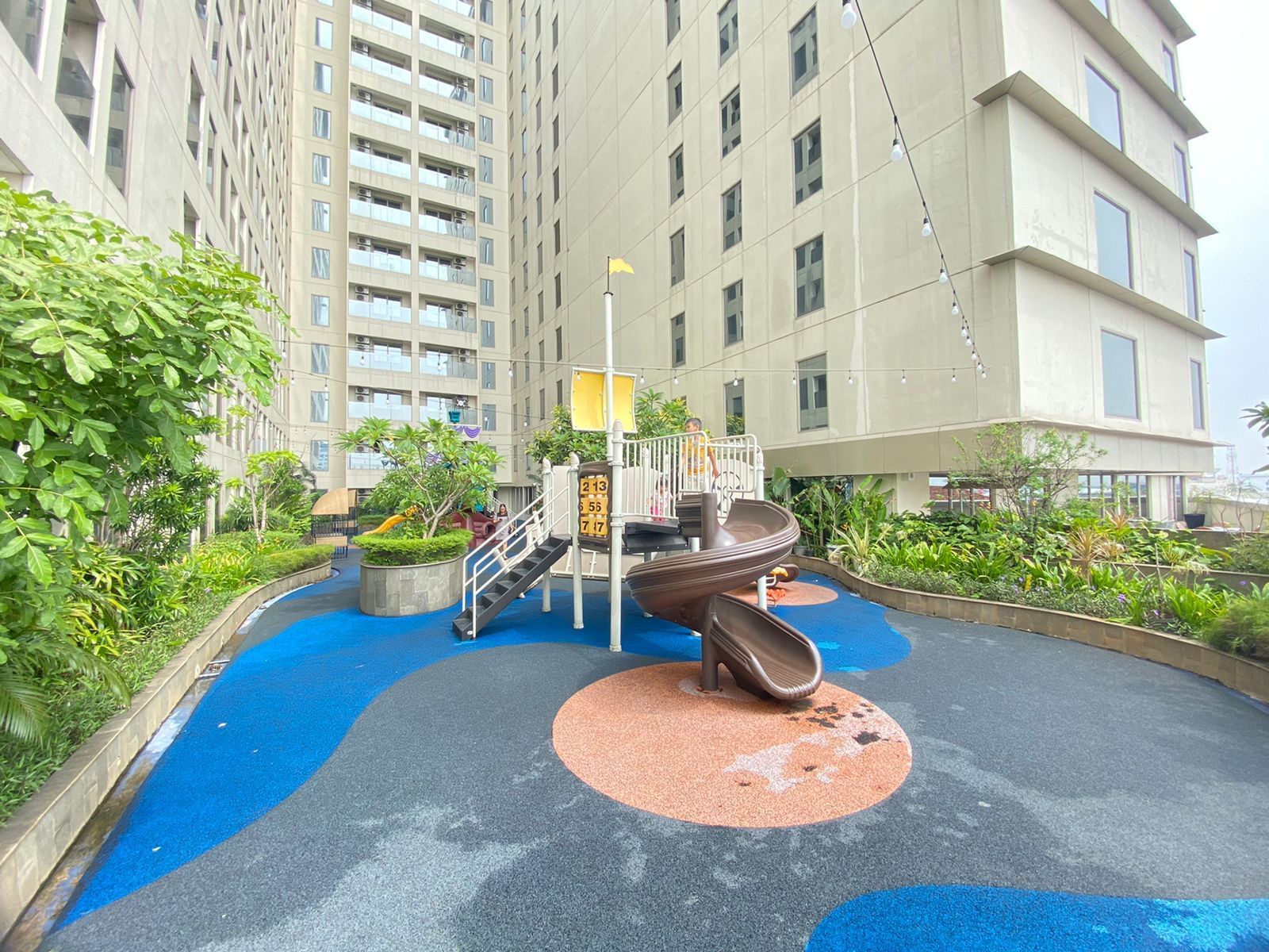 Playground in a courtyard with a building in the background at LK Pemuda Semarang Hotel & Residences