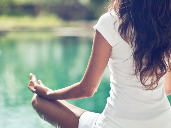 A lady meditating by the lake at Ana Hotels Europa