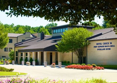 The exterior of the Bolger Center's main entrance, with a sign for the hotel check-in and Pony Express bar & Grill