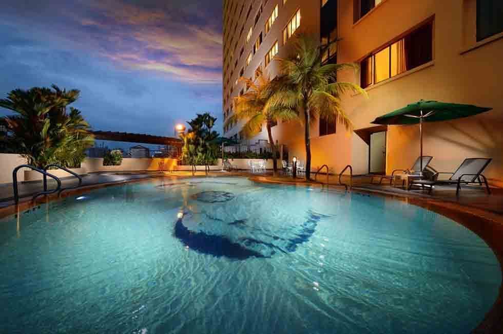 Exterior of the outdoor pool with skyscraper in the night at Sunway Hotels & Resorts