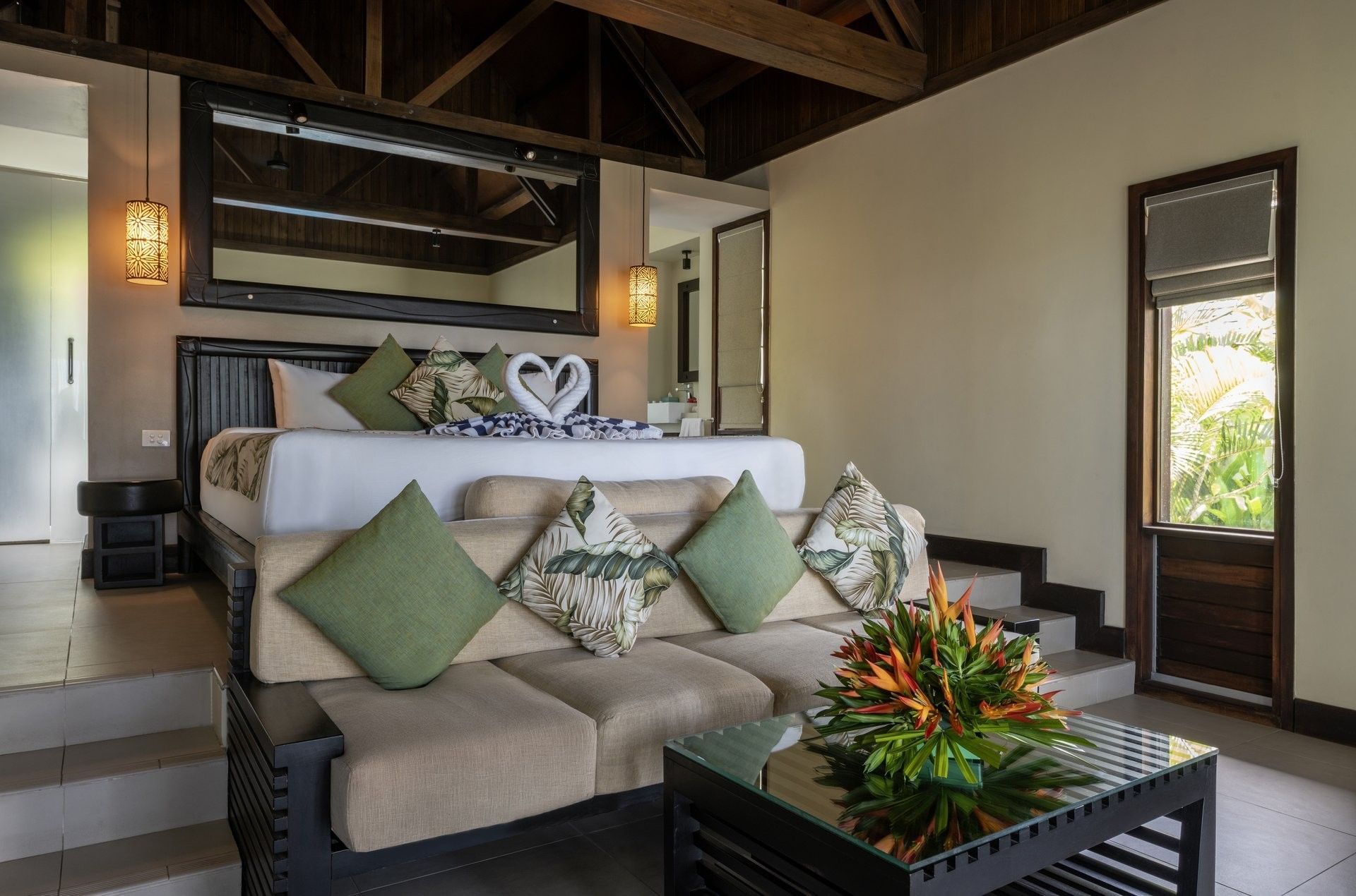 Elegant sofa & green cushions by a glass table Beach Front Bure with Plunge Pool at Tambua Sands Beach Resort