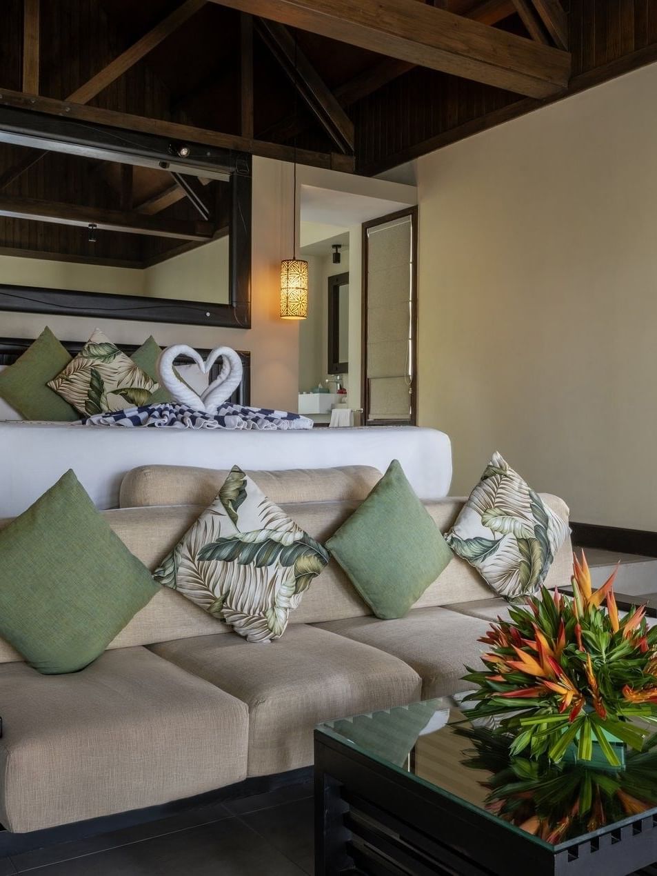 Elegant sofa & green cushions by a glass table, Beach Front Bure with Plunge Pool at Tambua Sands Beach Resort