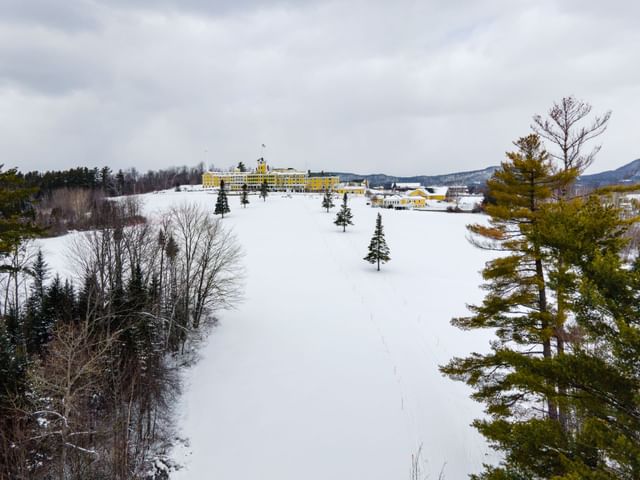 Distant view of Mountain View Grand Resort & Spa covered in snow and surrounded by trees in a winter landscape