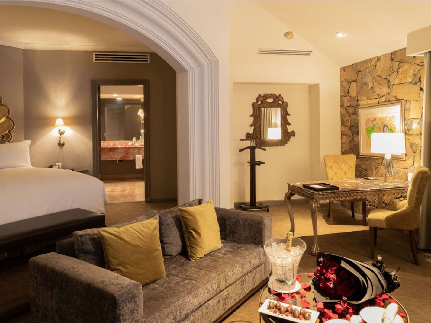 King Grand Class with rose petals, champagne, and a rustic stone wall in the lounge at Quinta Real Monterrey