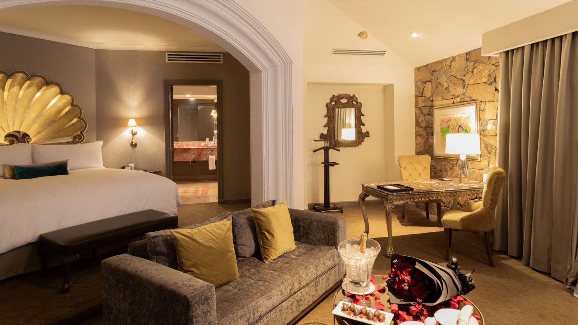 King Grand Class with rose petals, champagne, and a rustic stone wall in the lounge at Quinta Real Monterrey