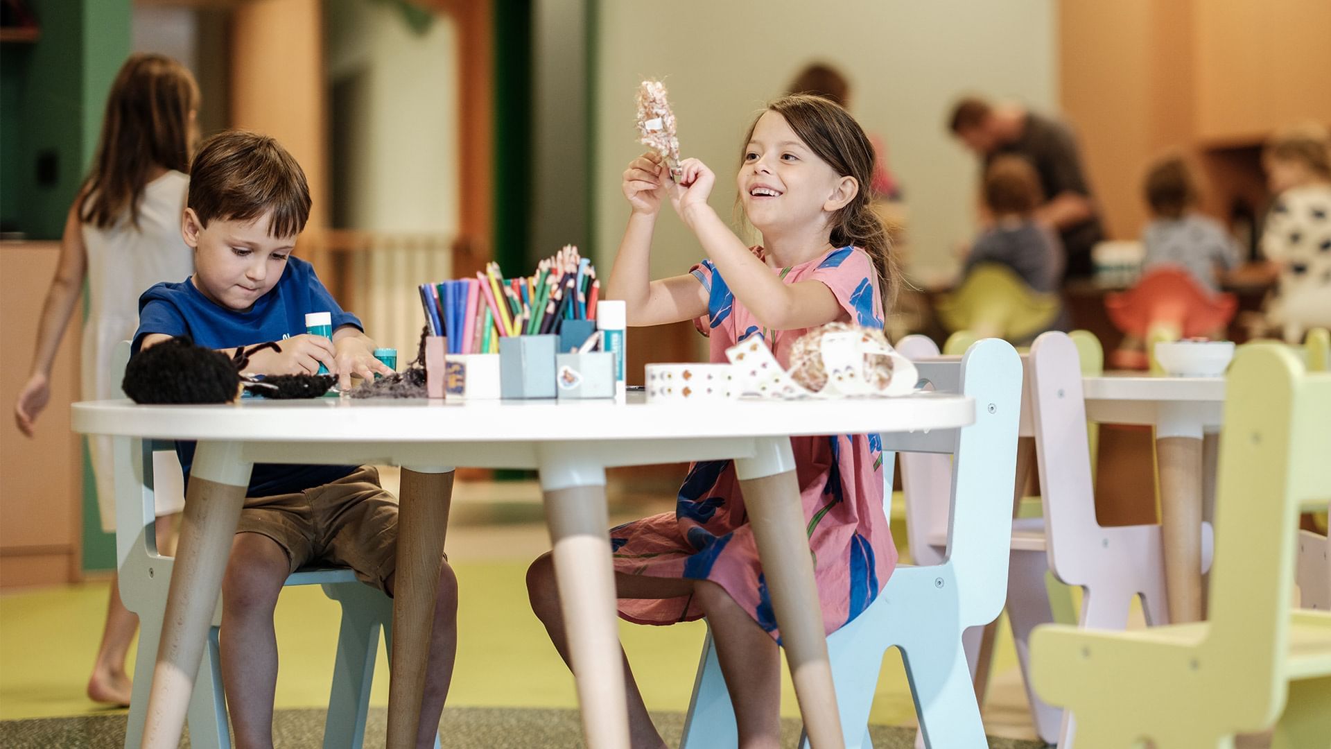 Children sitting and engaging with activities in Kids Area at Falkensteiner Hotel Montafon