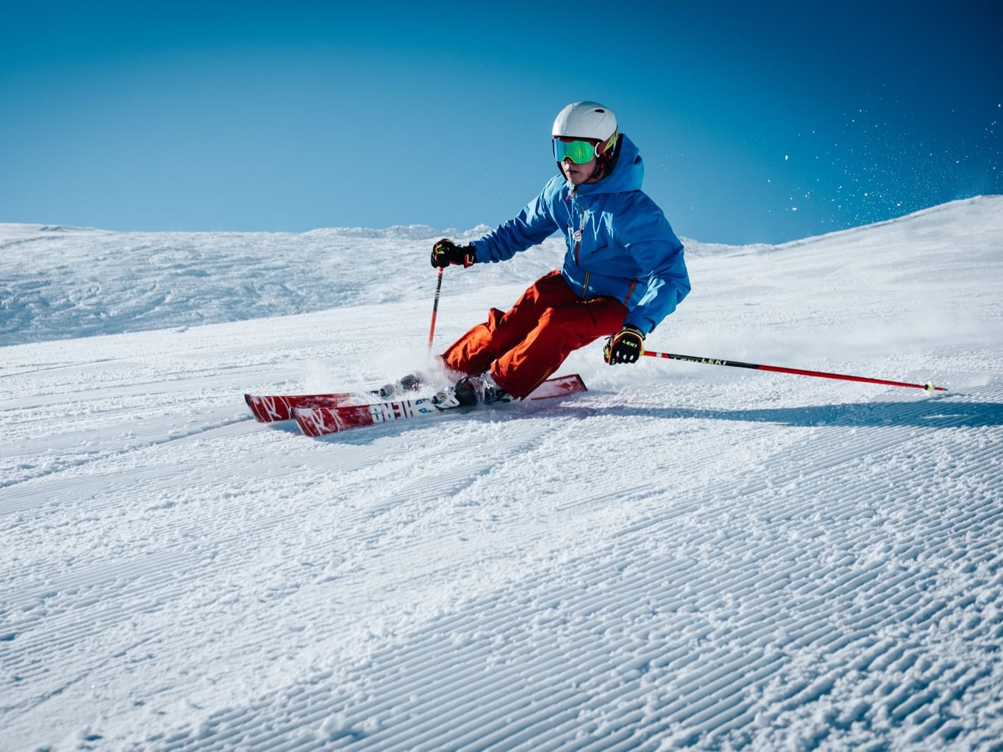 Skieur sur une piste avec ciel bleu activites hotel les gentianettes
