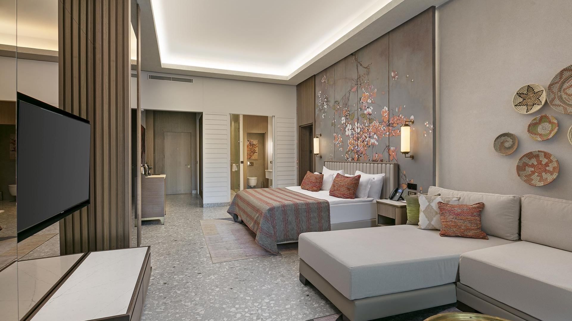 TV lounge area by the bed in Family Suite Swim-up with floral wall art at Cullinan Belek