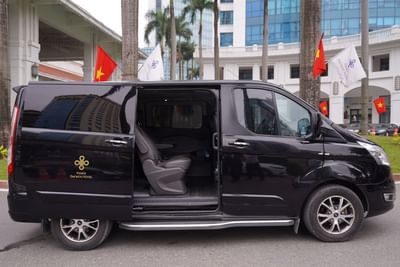 A van with an open door & the seats visible at Hanoi Daewoo Hotel