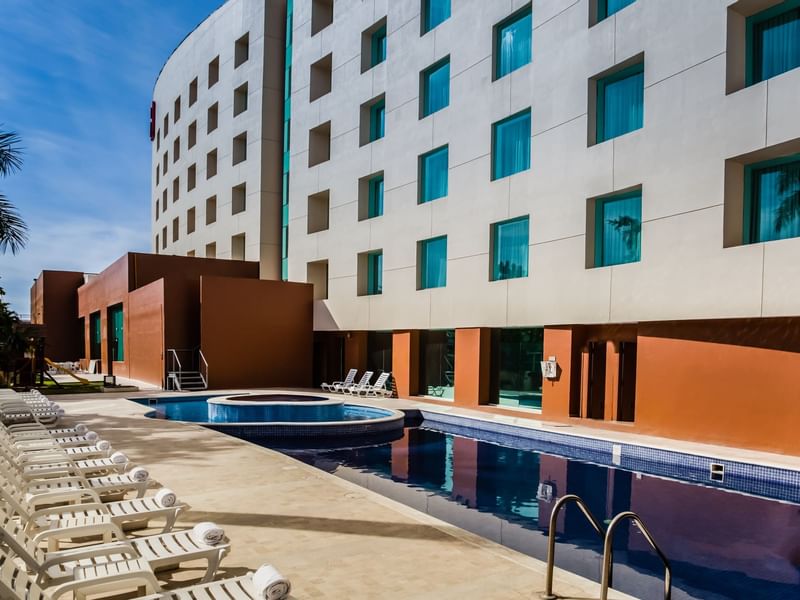 Outdoor swimming pool with sunbeds at Fiesta Inn Hotels