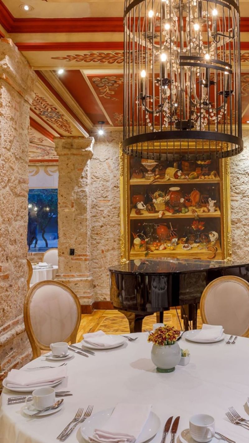 Tierra Mia restaurant featuring a black grand piano and a birdcage crystal chandelier at Quinta Real Guadalajara