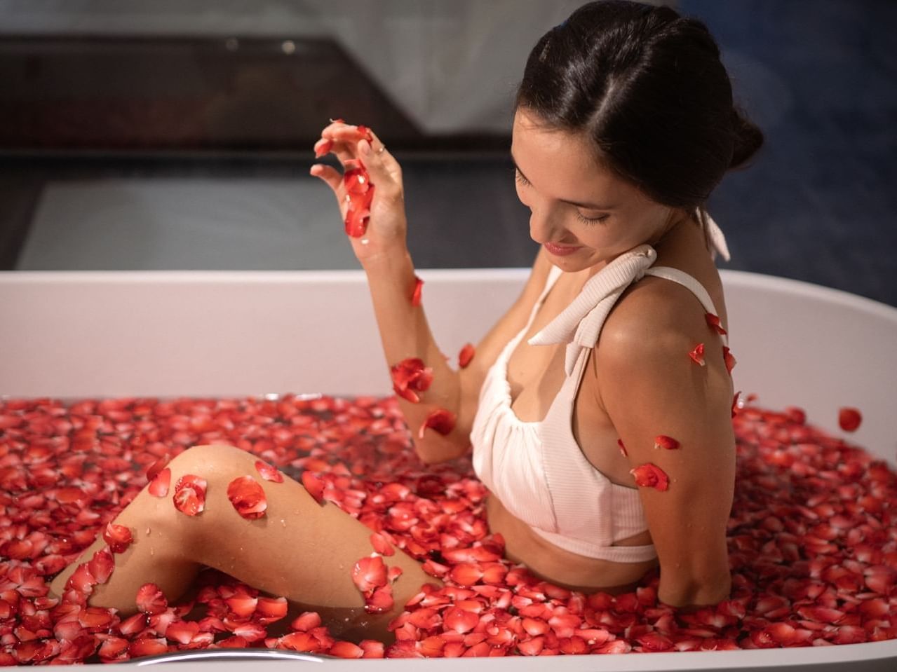 A lady in a bathtub with red rose flowers at Chatrium Grand Bangkok