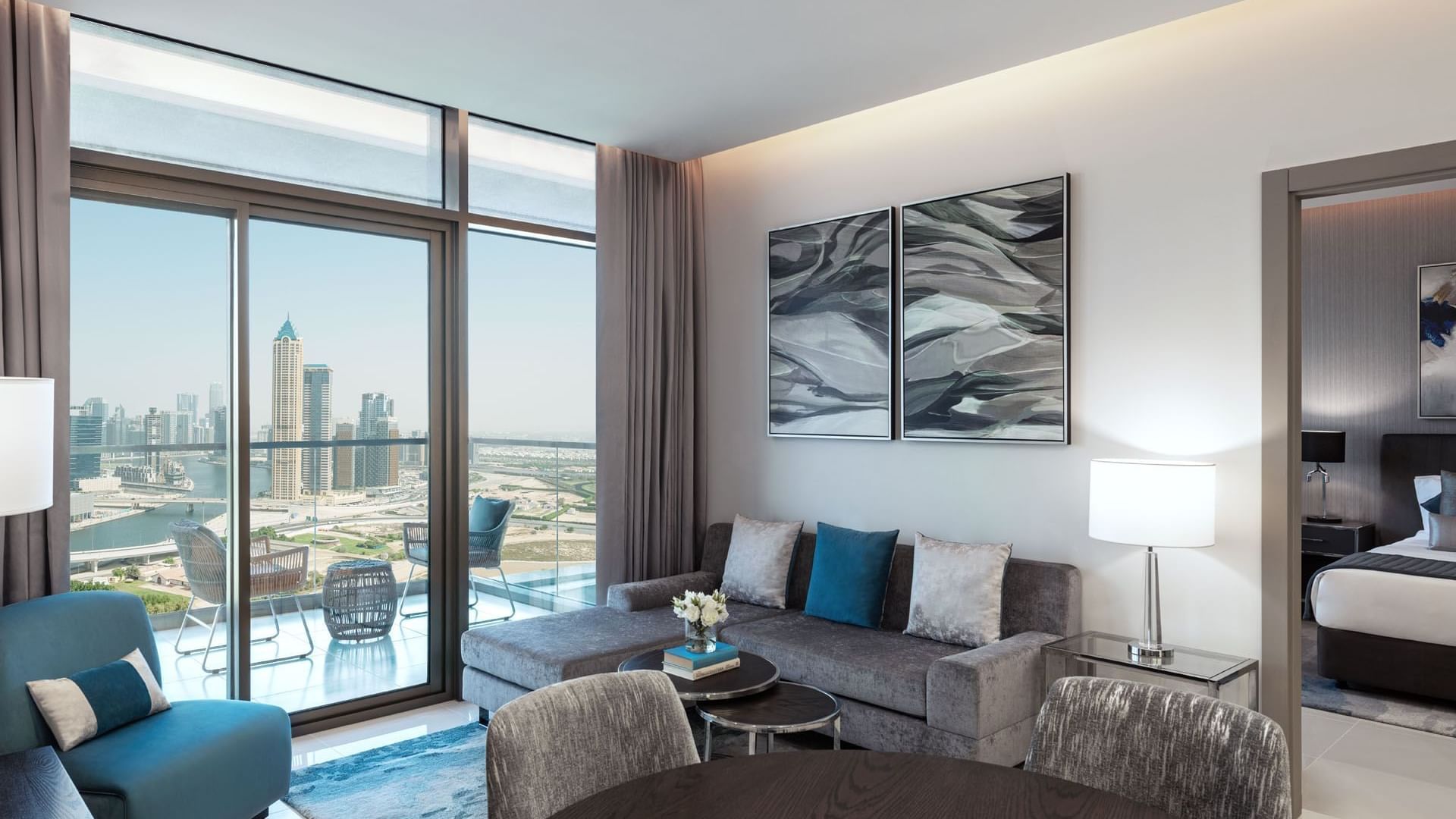 Cozy sofa with a city view in Two Bedroom living area & balcony at DAMAC Maison Aykon City Hotel Apartments