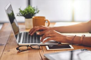 Woman using Bayside Inn Key Largo's high-speed internet on her laptop to knock out work while vacationing.