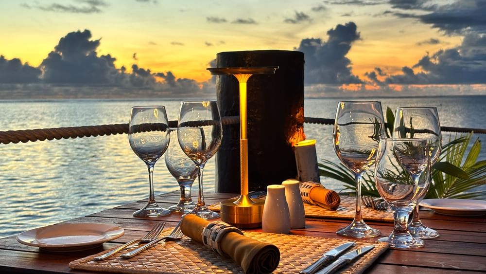 Set table with ocean view at sunset at Wicked Walu in Korolevu at Warwick Fiji Resort and Spa.