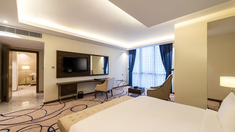Cozy bed, TV, and working table in Executive Suite at Warwick Riyadh