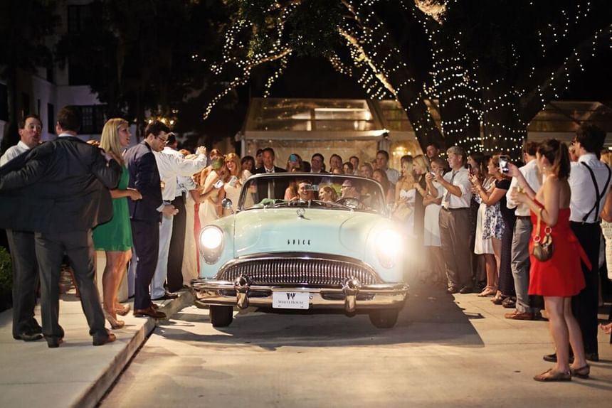 A couple departing their wedding in a light blue vintage Buick convertible at The White House Hotel